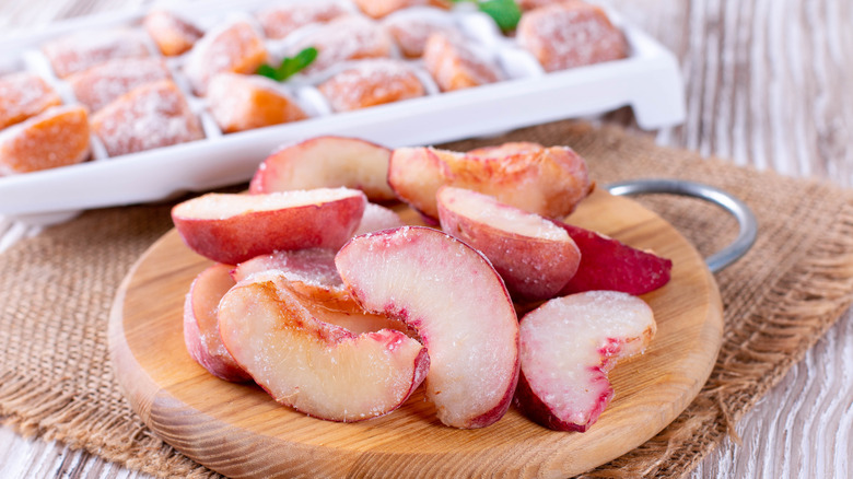 Frozen peaches on wooden board