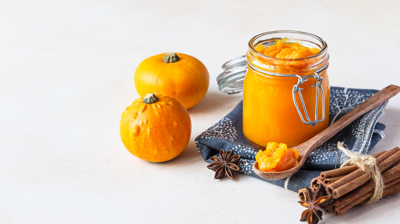 A jar of pumpkin puree alongside some spices