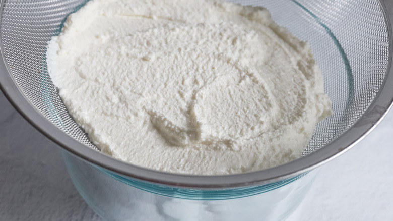 ricotta cheese draining in sieve