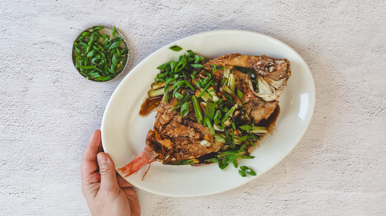 Hand serving platter with fish