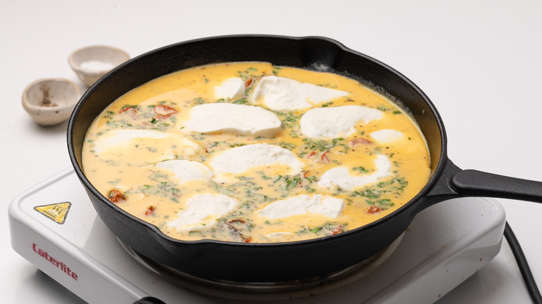 frittata cooking in skillet pan