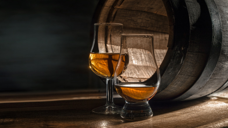 Glasses and wood barrel at distillery