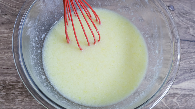 whisking wet donut dough ingredients