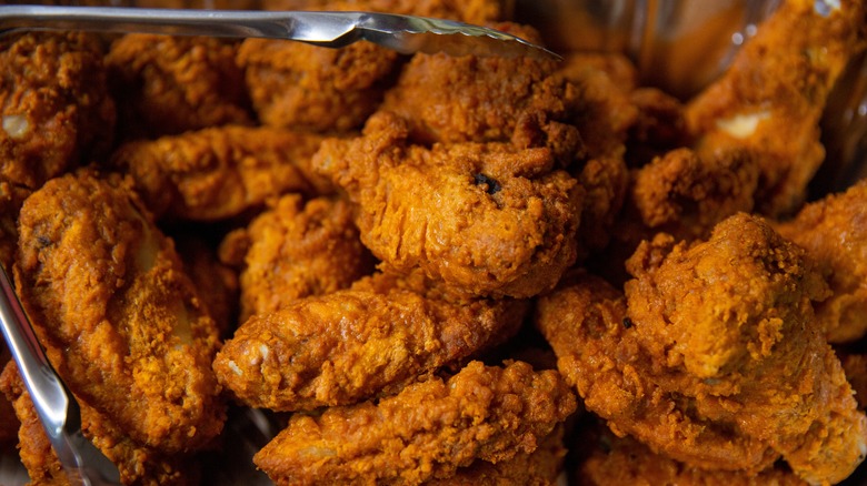 fried chicken wings with tongs