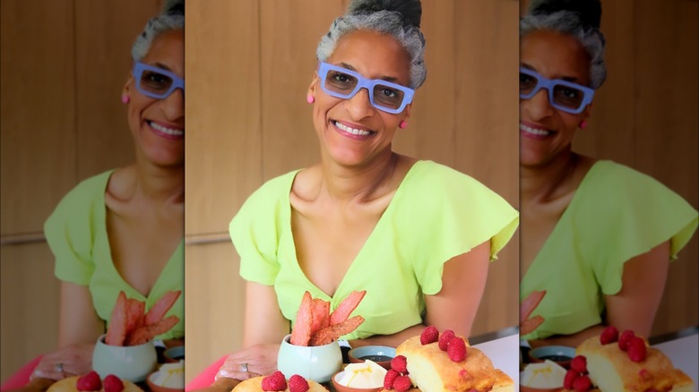 Carla Hall sitting at table in green dress