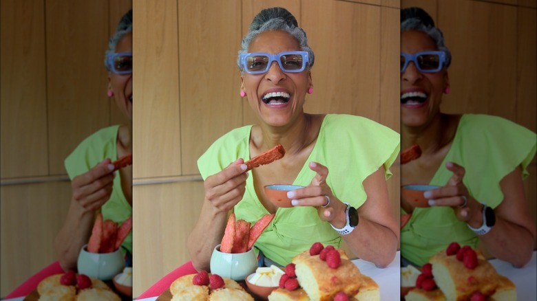 Carla Hall eating cake and laughing 