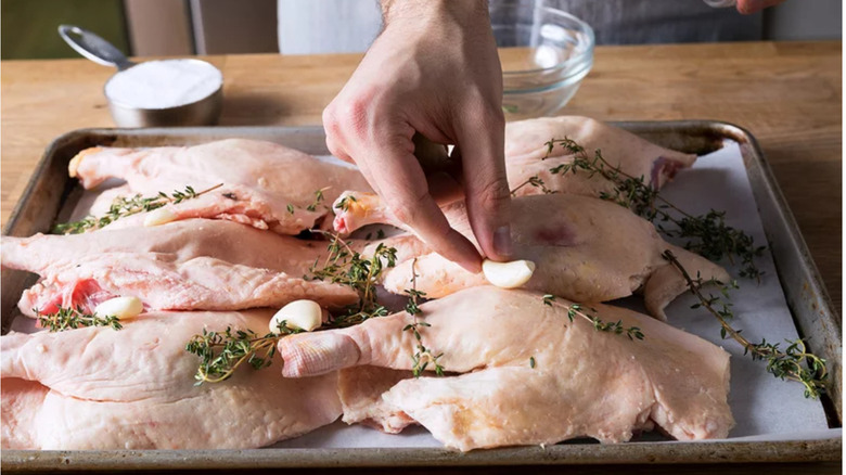 hand placing garlic on duck