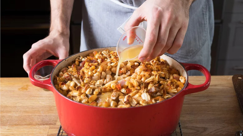 Stock being poured on cassoulet