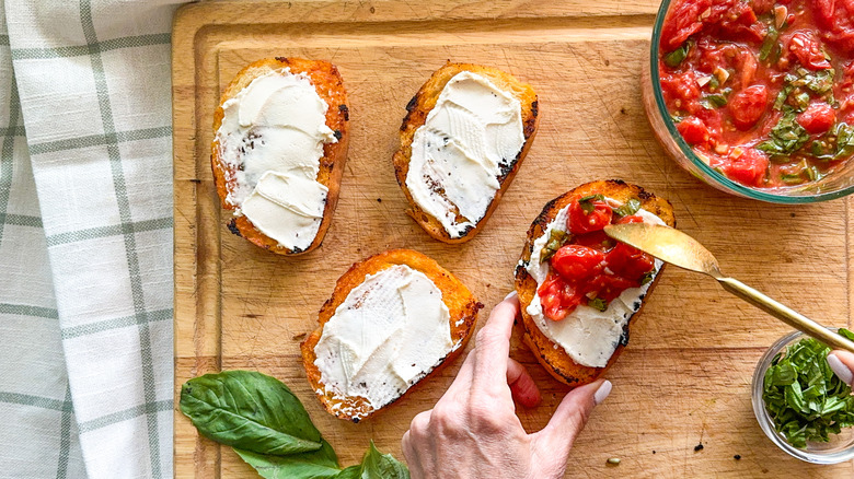 Adding tomatoes to bread