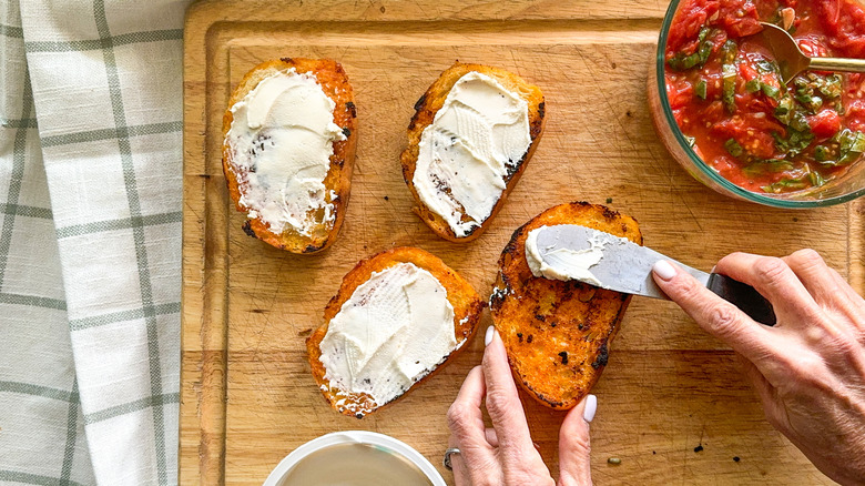 spreading cream cheese on bread