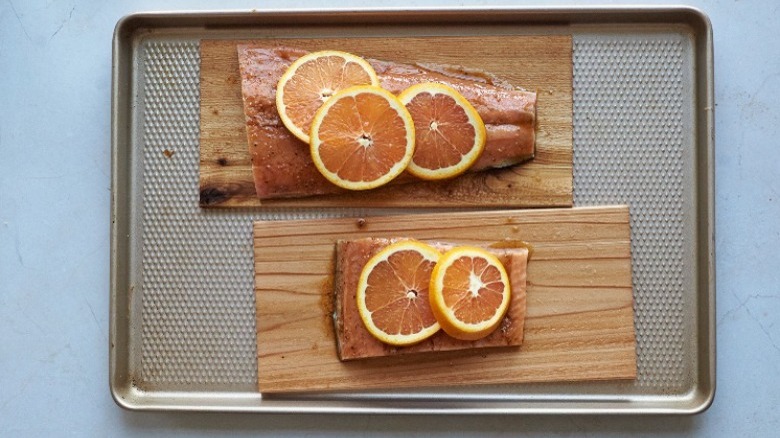 salmon on planks with oranges
