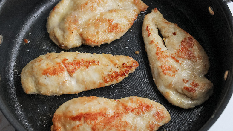 chicken breasts cooking in pan