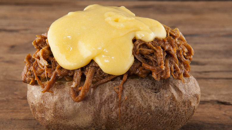 Pulled pork and melted cheese on baked potato