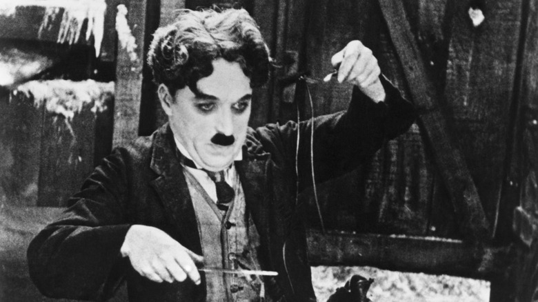 Charlie Chaplin holding silverware