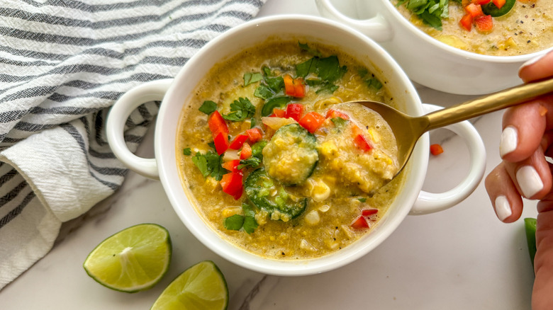 hand with spoon in soup