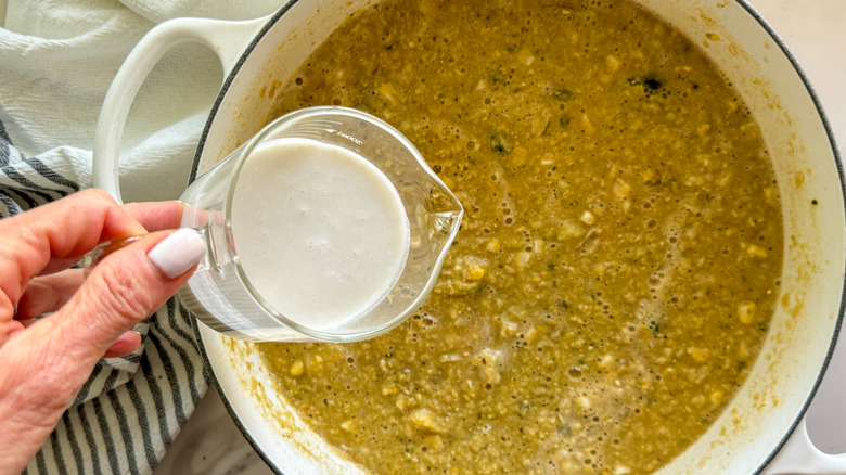 hand pouring cream in pot