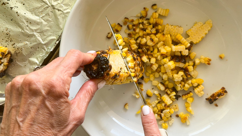 hand cutting corn off cob