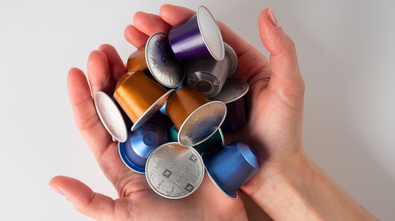 hands holding Nespresso pods