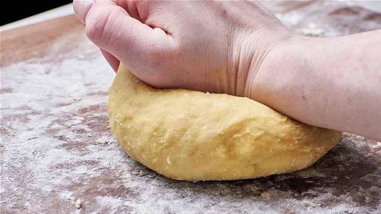 kneading dough on a floured surface