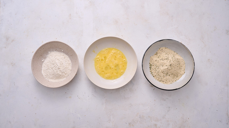 egg, flour, and breadcrumbs in bowls