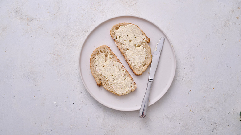 buttering bread on plate