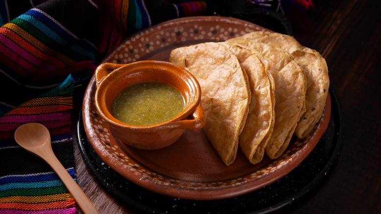 fried quesadillas on a plate with salsa verde