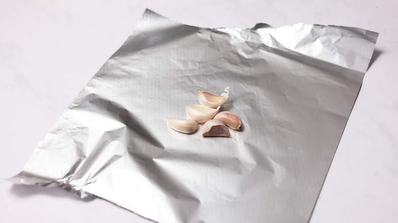 garlic cloves on aluminium foil 