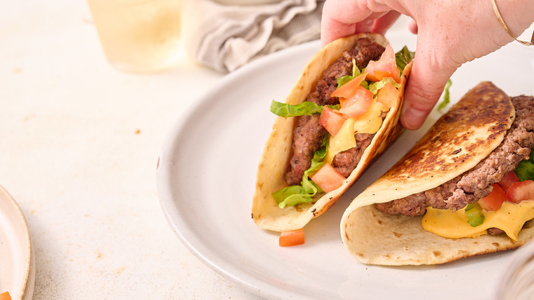 lifting smashburger taco off of plate