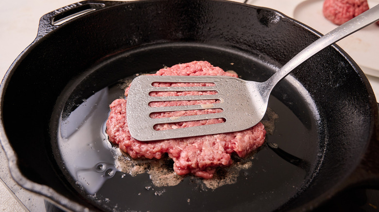 smashing burgers with spatula