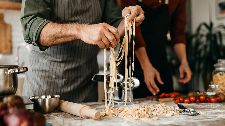 person making pasta in kitchen