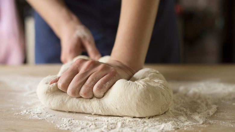 Person kneading dough on counter