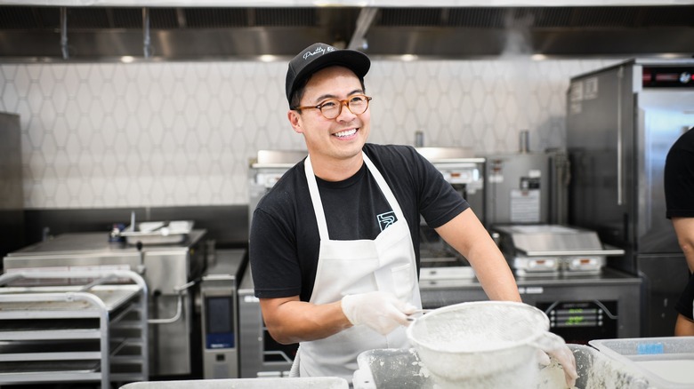 Viet Pham smiling while cooking