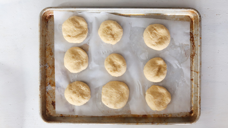 dough balls flattened on parchment paper