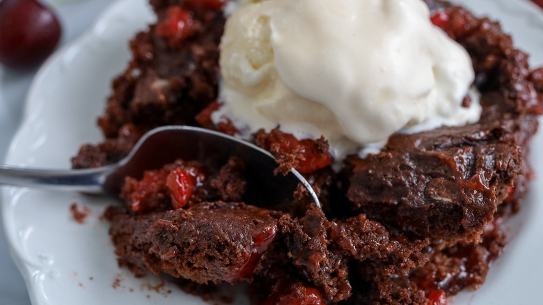 cherry cola dump cake being scooped with a spoon