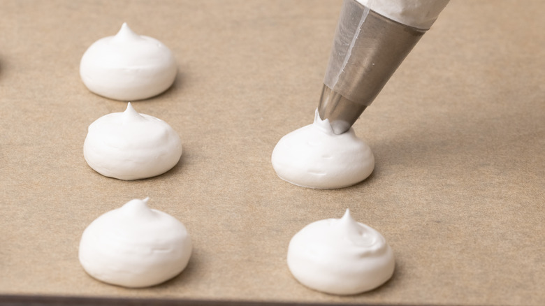 Piping meringues onto baking tray 