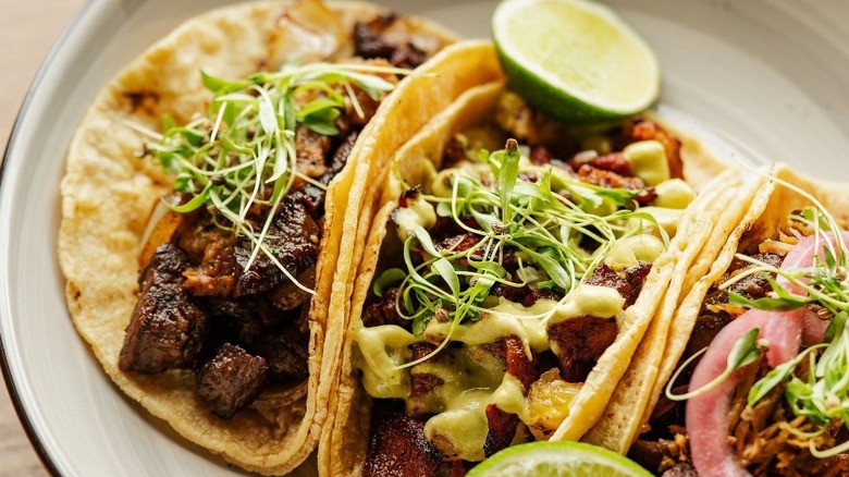 trio of tacos with limes