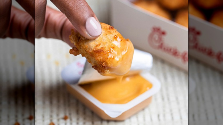 Chick-fil-A nugget being dipped in sauce