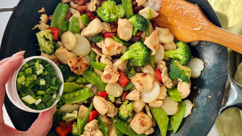 adding scallions to chicken almond gai ding