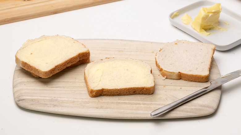 buttered bread on wooden board