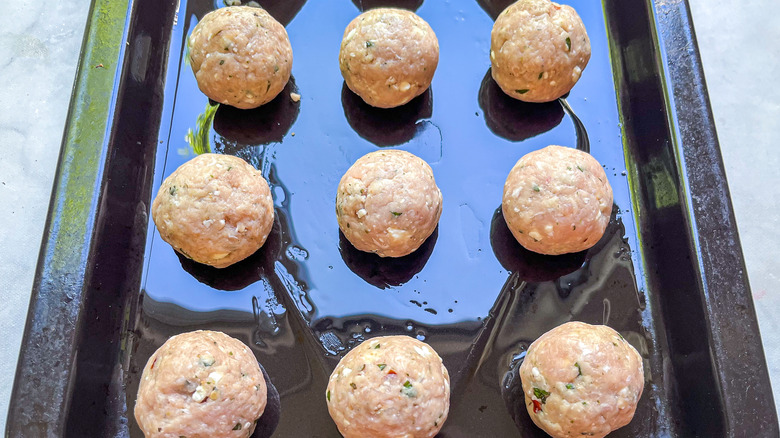 uncooked chicken meatballs on tray