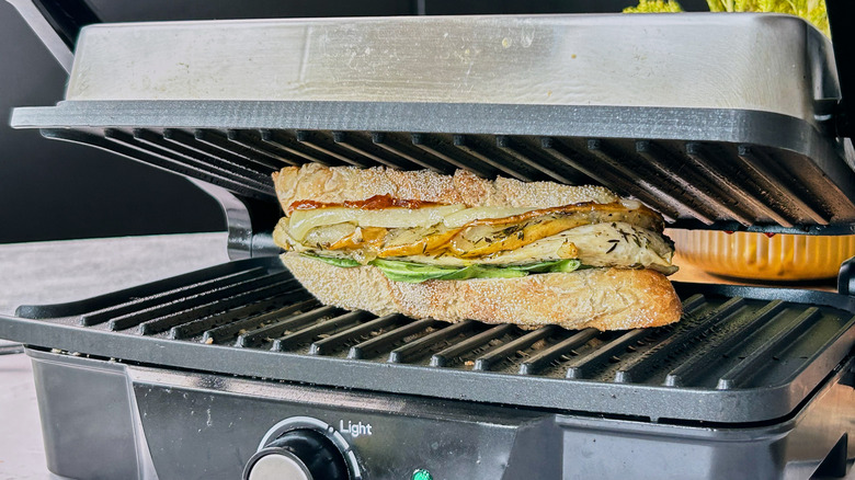 pressing sandwich on panini press