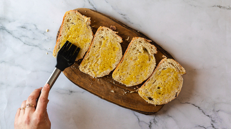 Brushing bread with olive oil