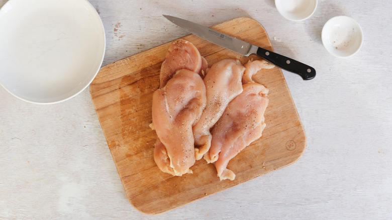 split and seasoned chicken breasts on plate