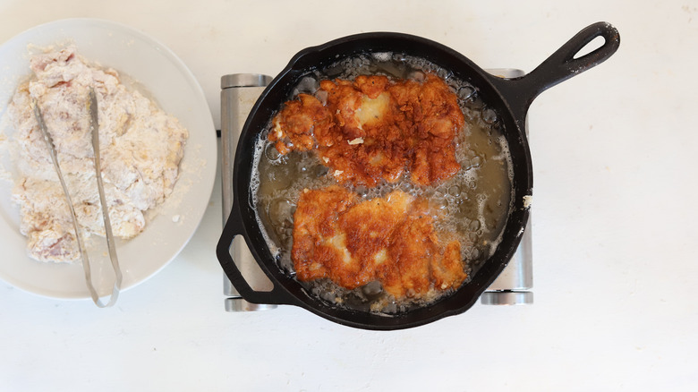 frying chicken in skillet