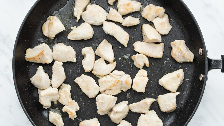 cubed chicken cooking in pan