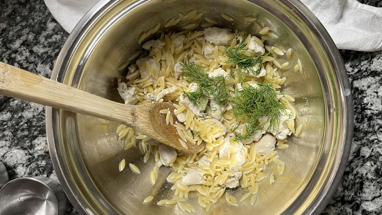 mixing orzo salad 