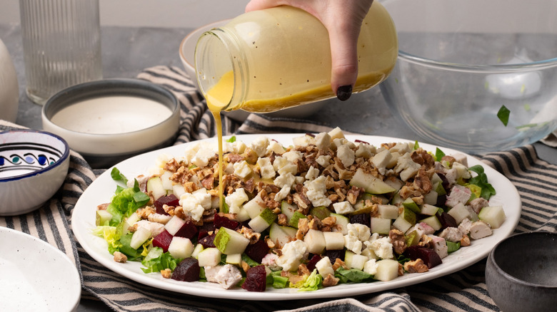 Pouring dressing on a salad