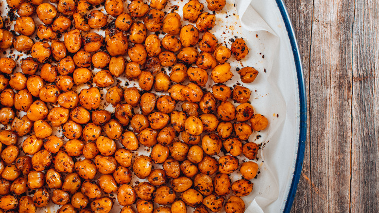 Roasted and seasoned chickpeas spread out on a plate 