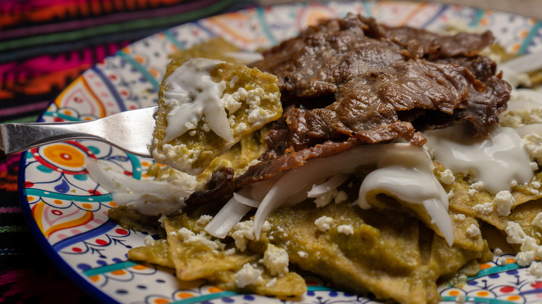 chilaquiles verdes topped with steak