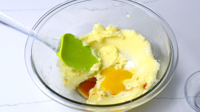 Liquid ingredients being added to dough for hazelnut thumbprint cookie 